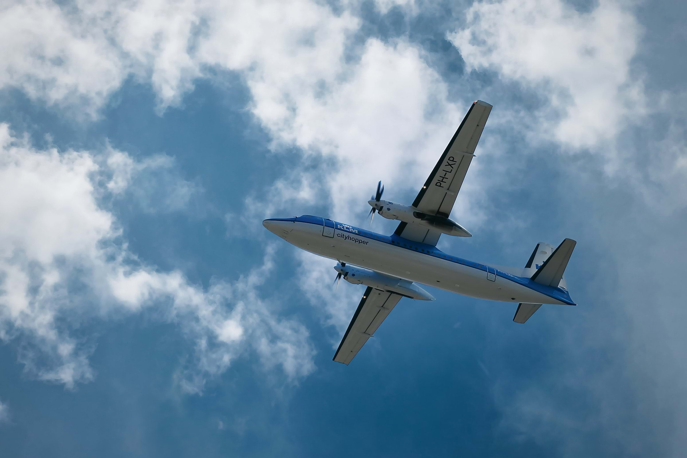 An aeroplane flying with a blue sky in the background
