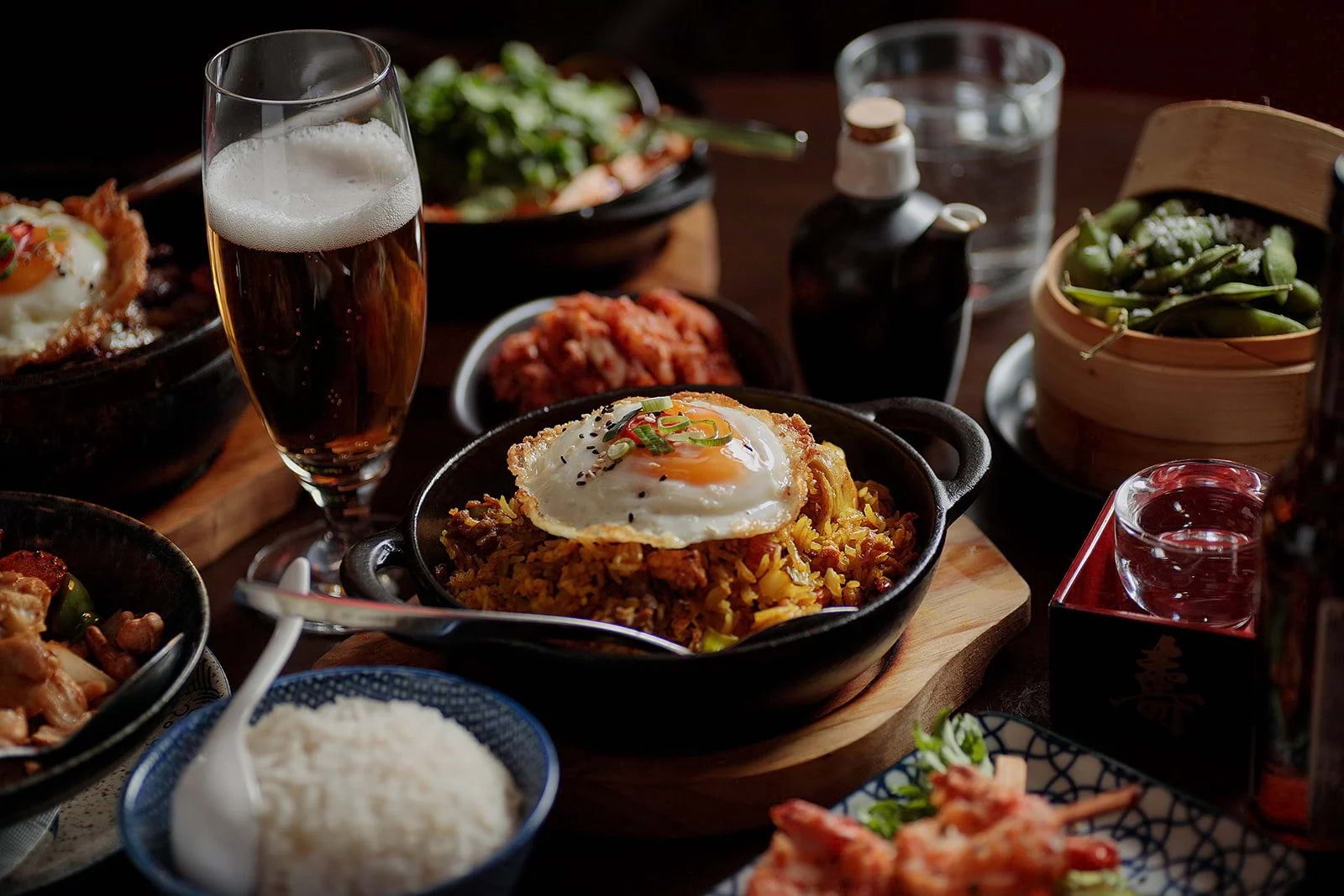 A table covered in Asian dishes, with nasi goreng in the centre