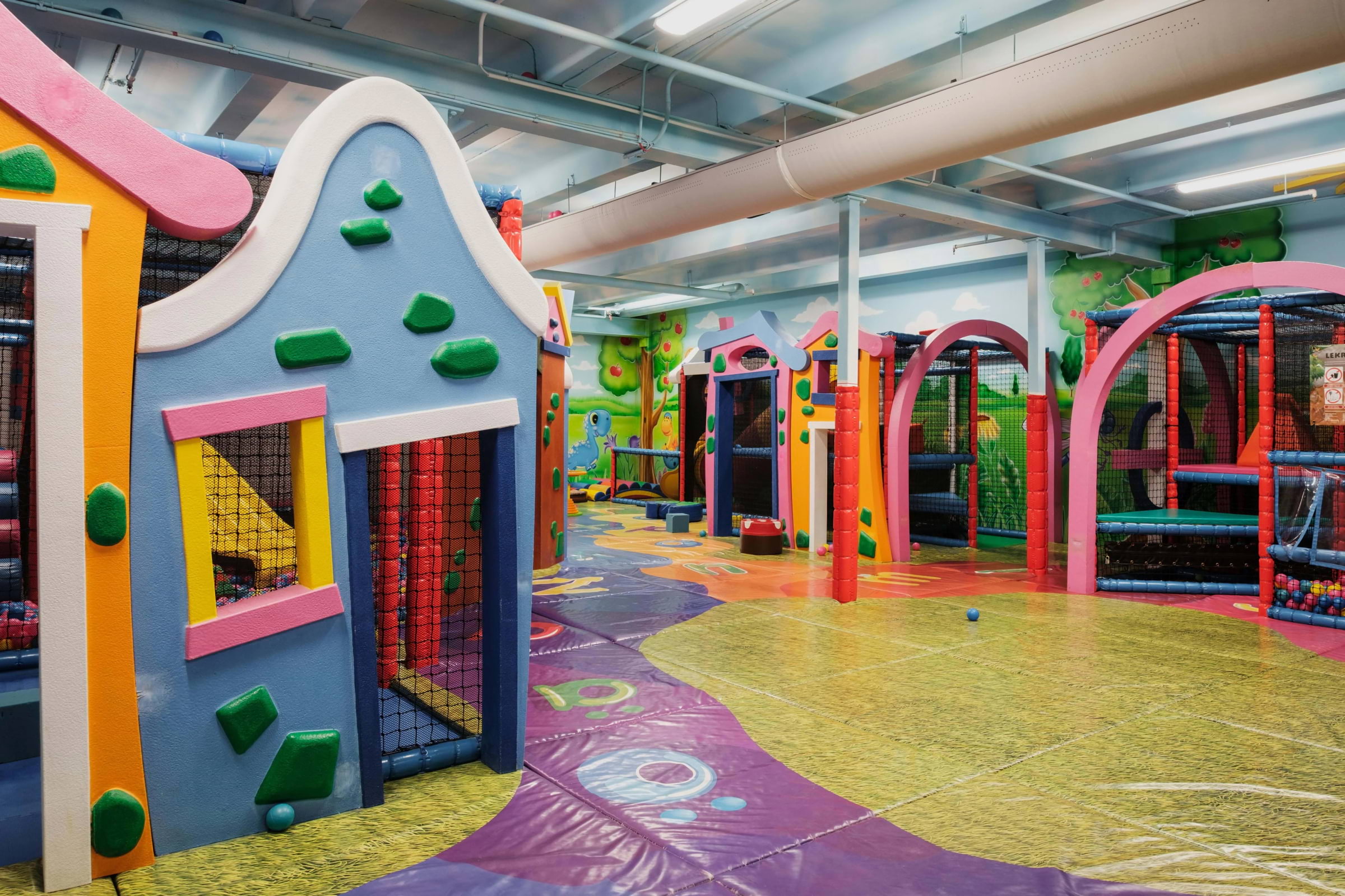 A colourful indoor soft play area themed as a village