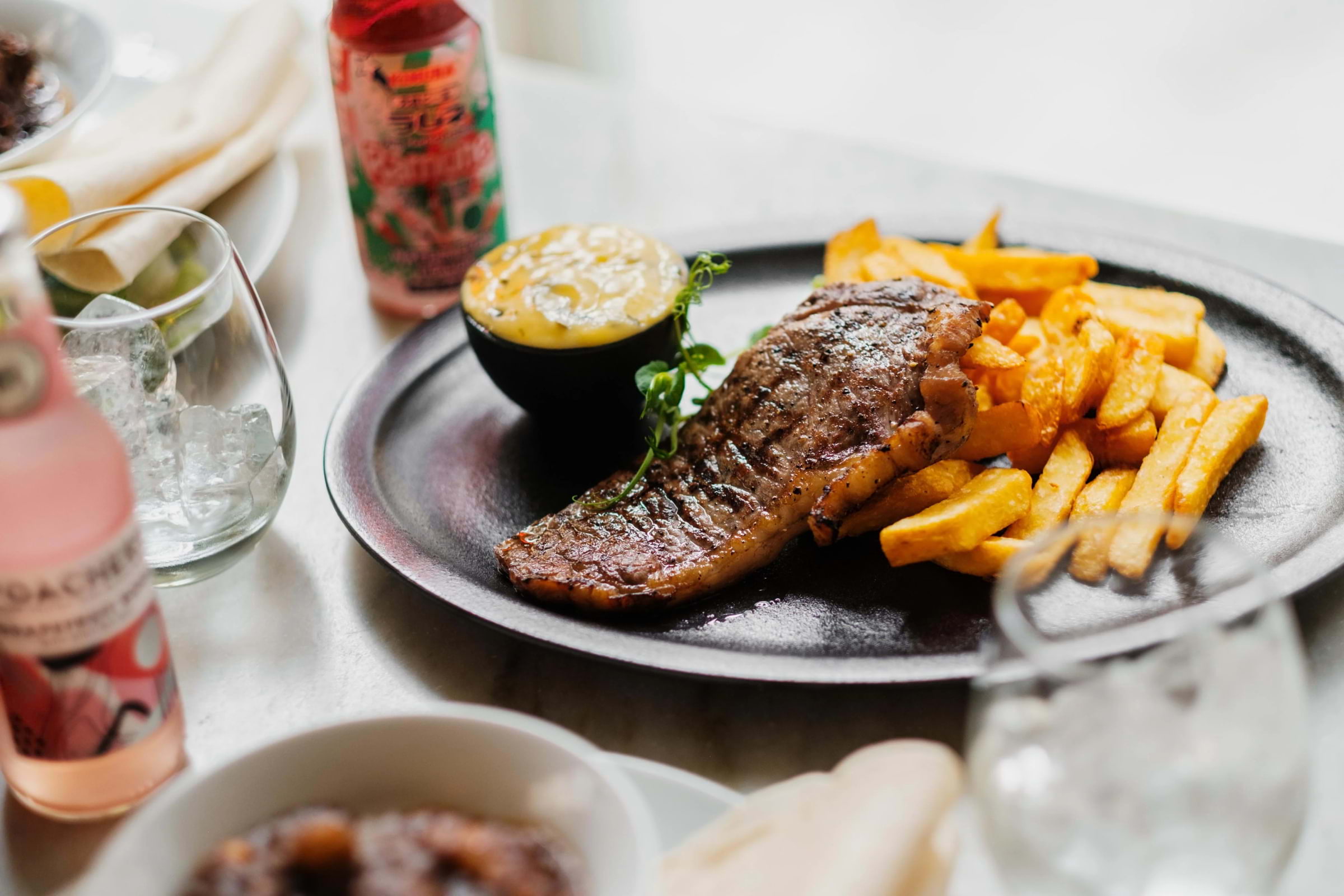 Steak, chips, and sauce on a plate in a restaurant