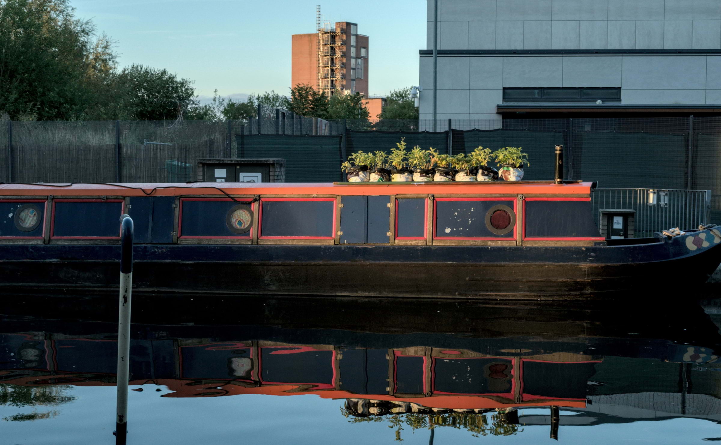 A black and red barge moored on the canal in Ancoats in Manchester