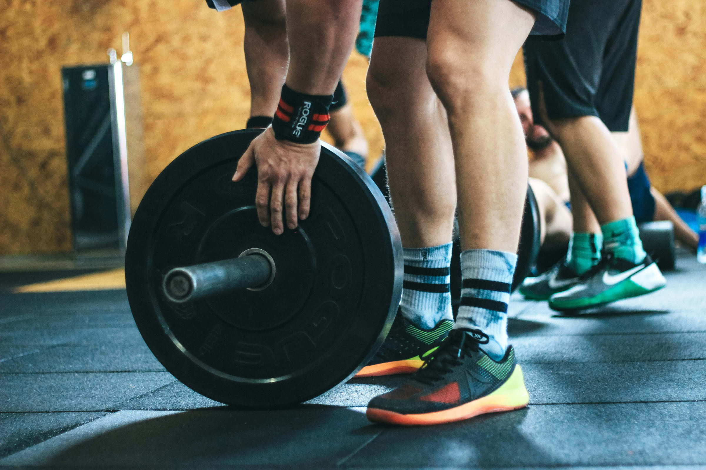 A man in gymwear changing weights on a barbell