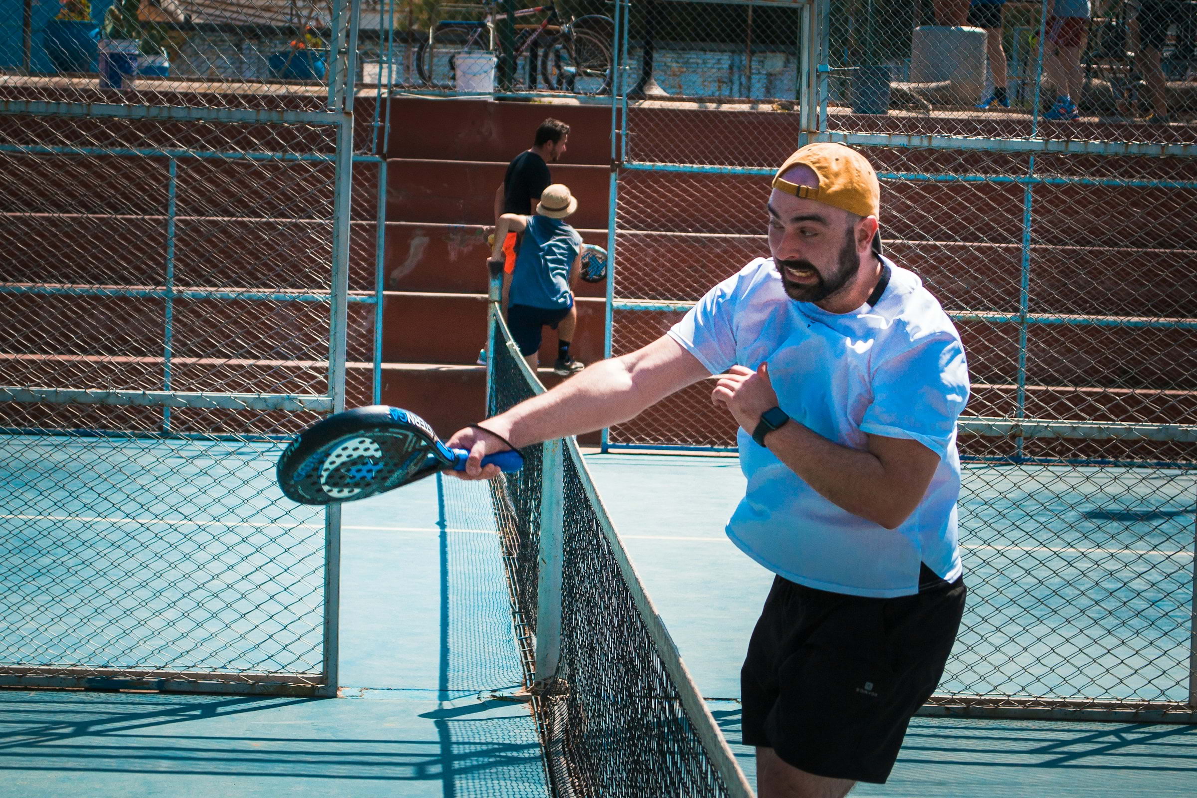 A man hitting with a padel racket on an outdoor court