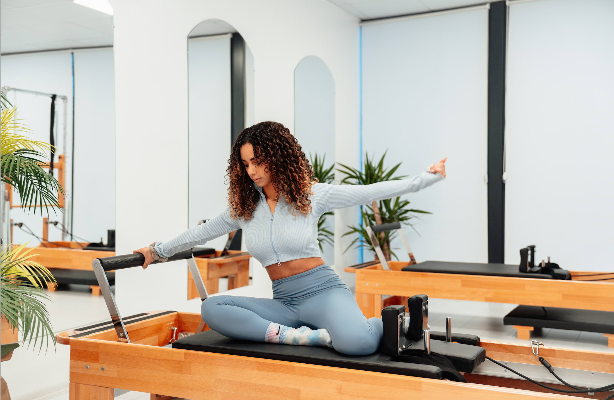 A lady doing pilates on a reformer pilates machine