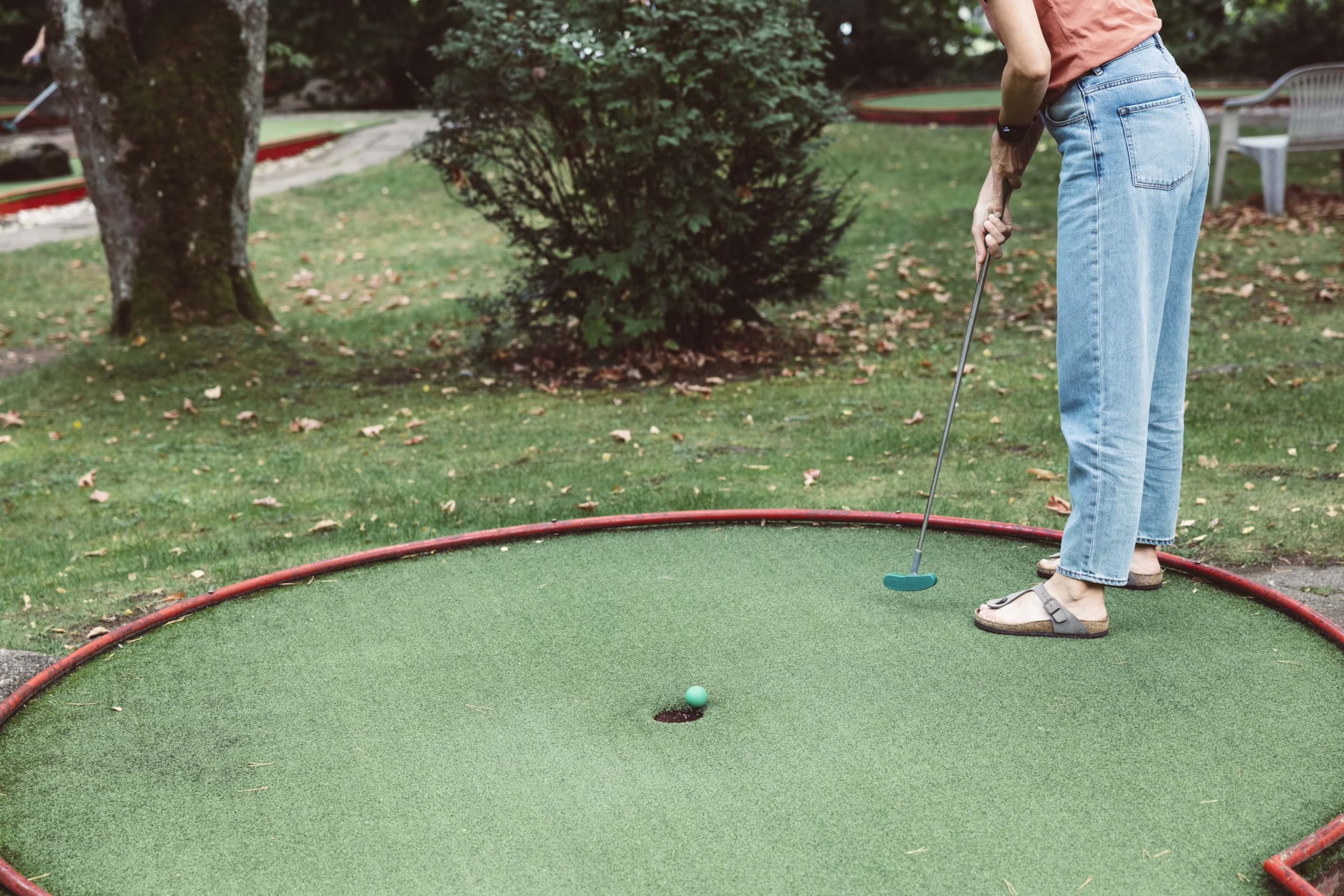 A woman playing on an outdoor mini golf course