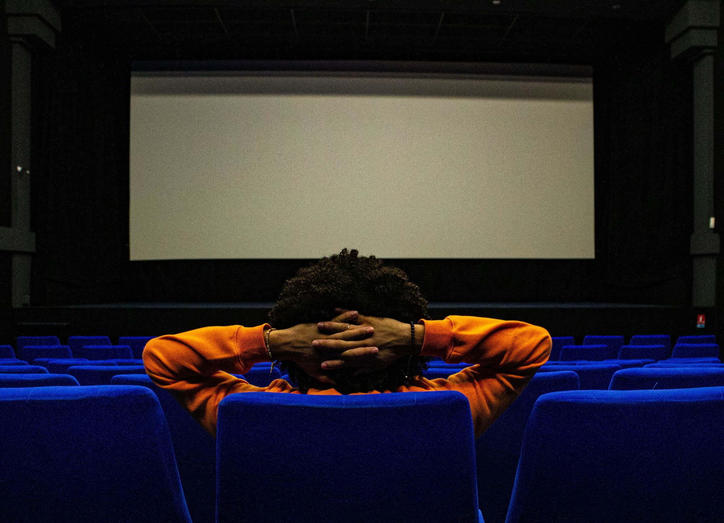 An audience member sitting in an empty cinema