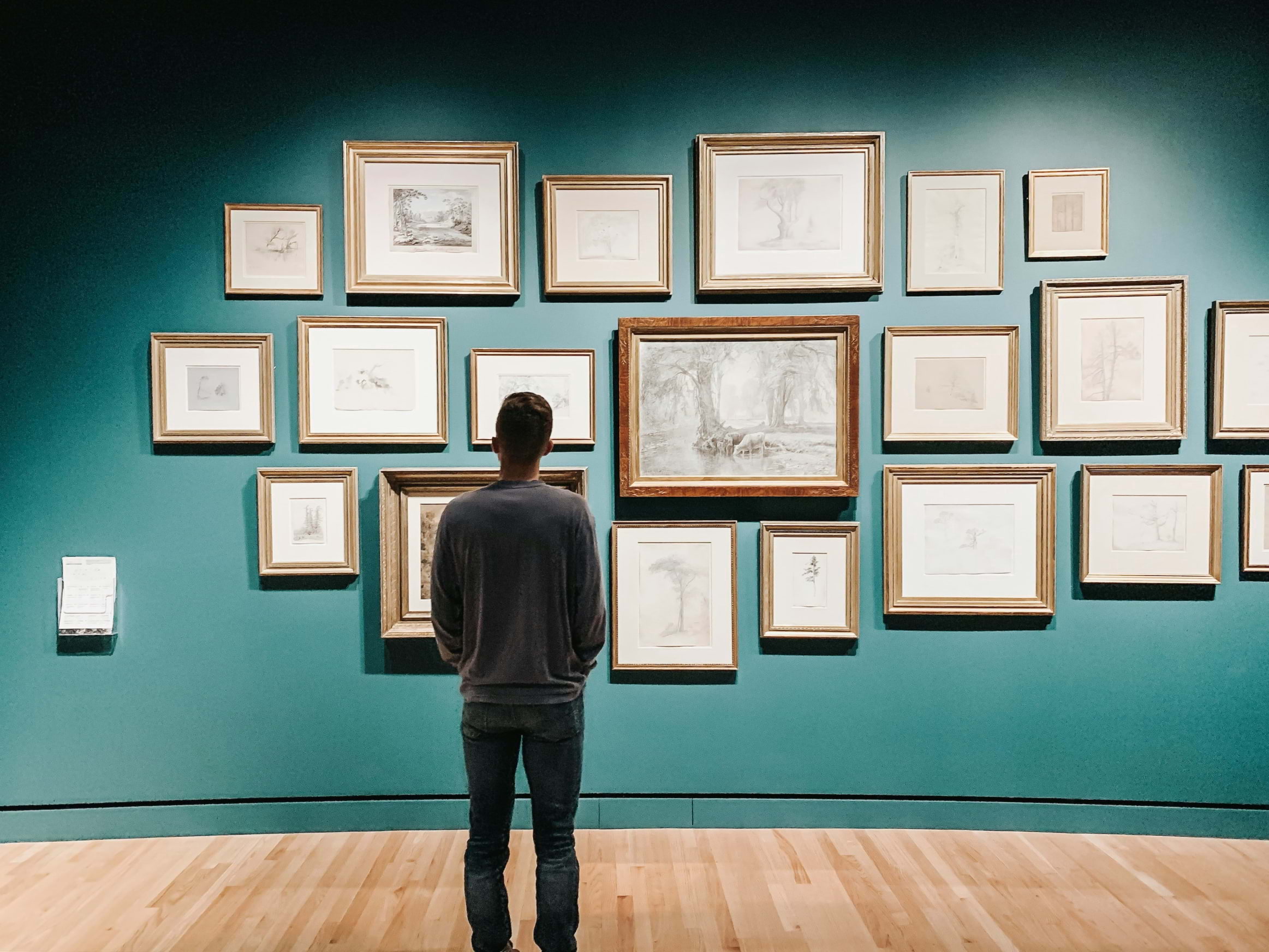 A man looking at an art gallery wall