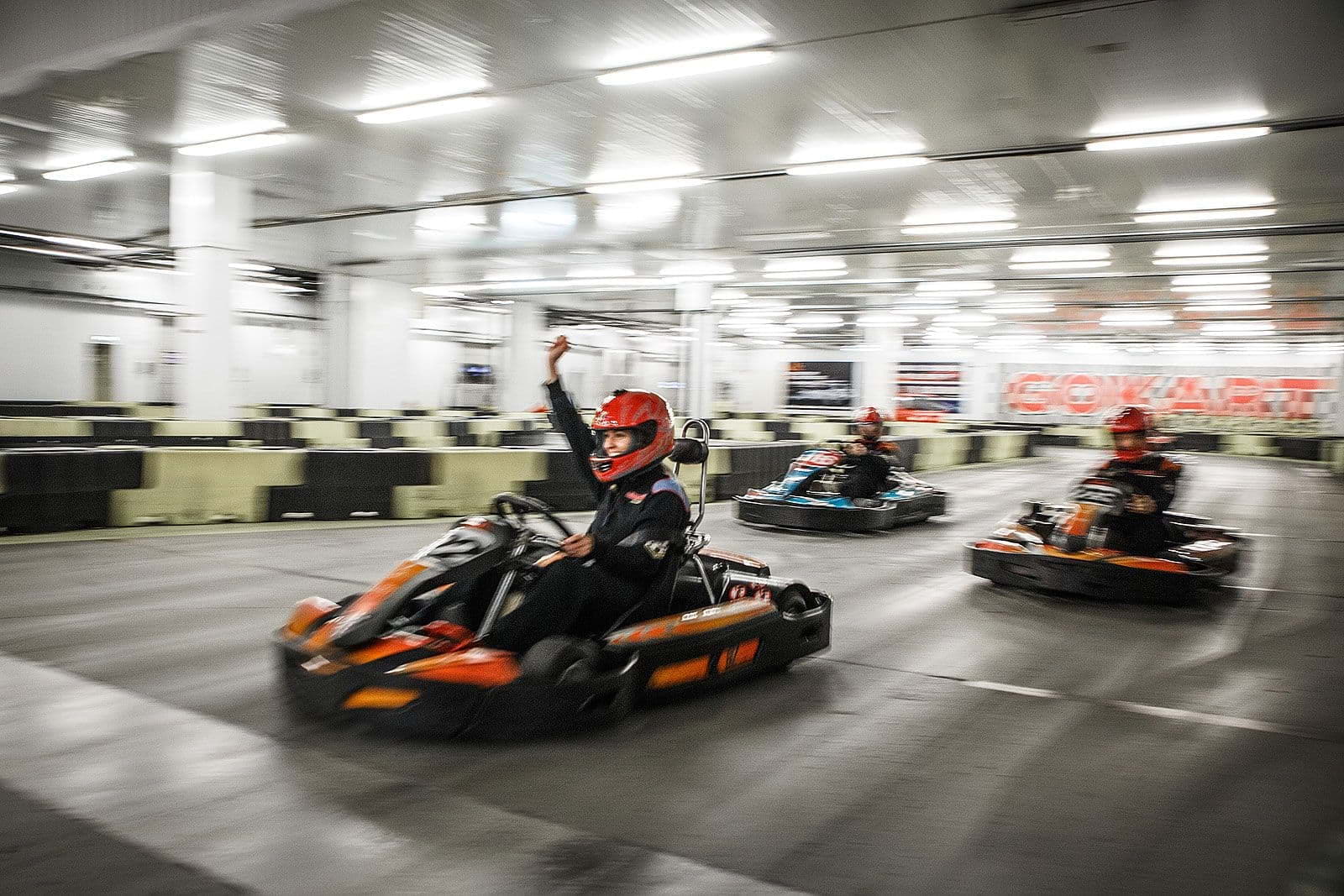 A driver celebrating as they cross the finish line on a go-kart track