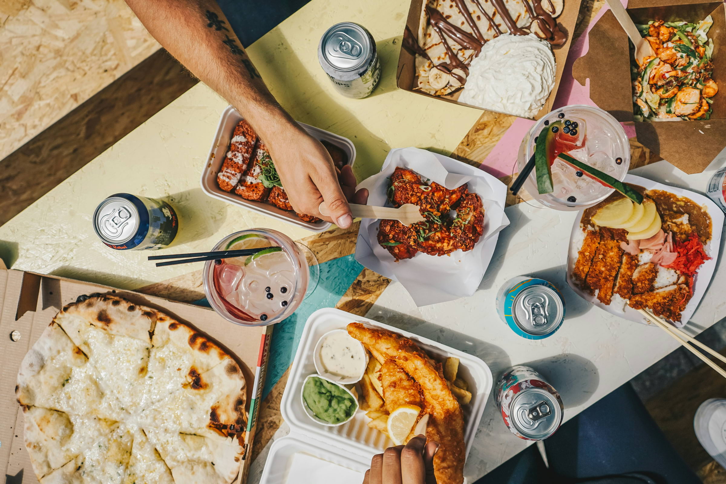 A bird's-eye view of people tucking into takeaway food on a table