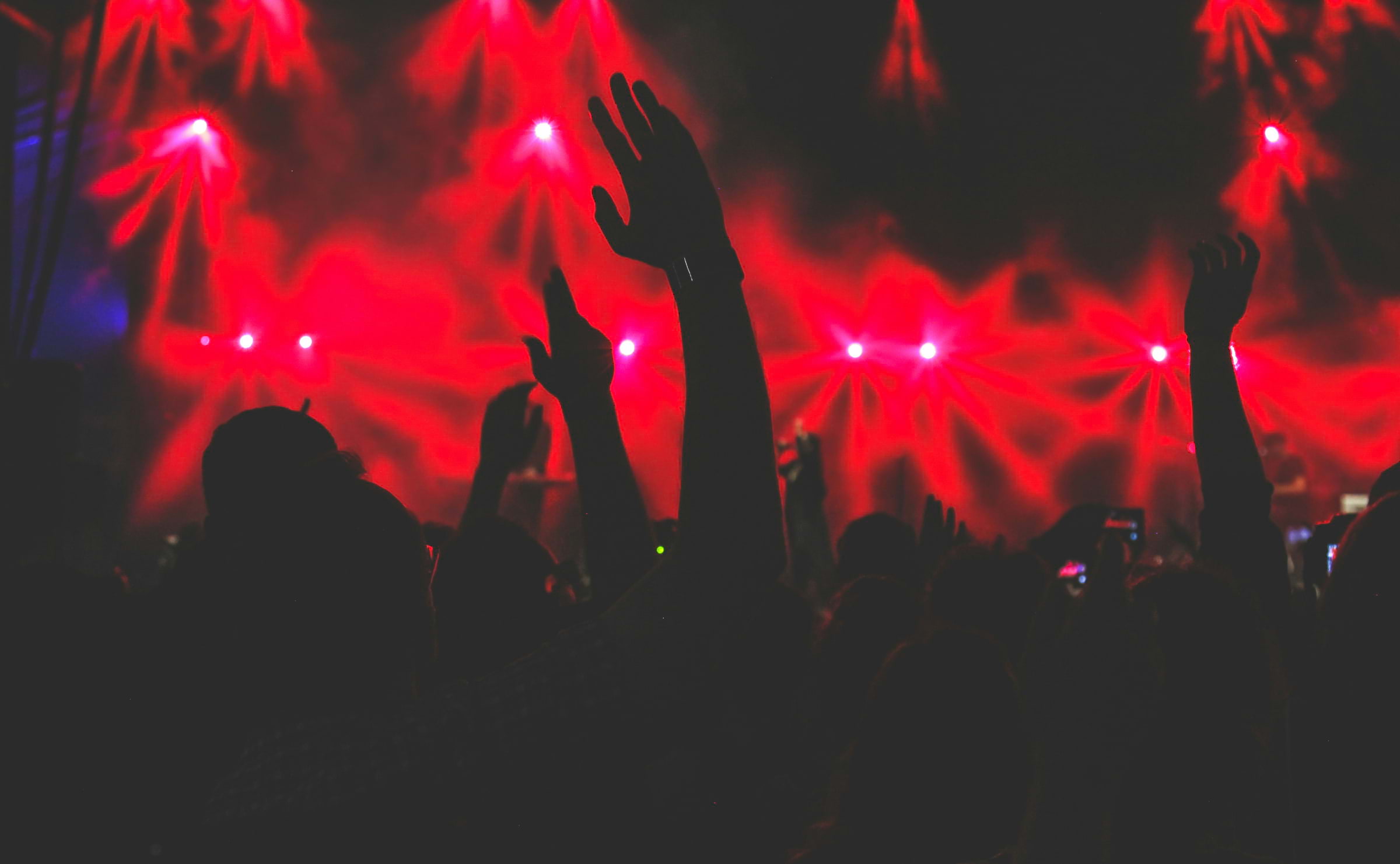 Silhouettes of people dancing with a red light-up background