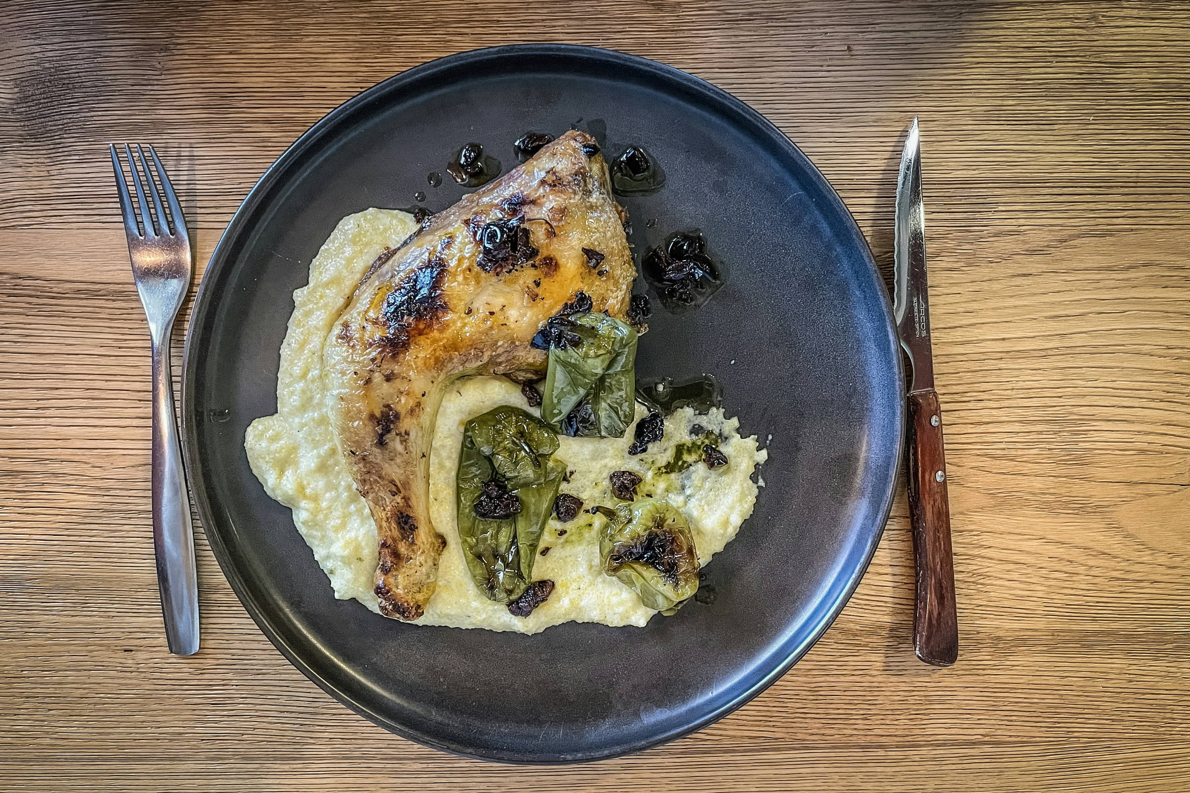 A chicken leg on a bed of mashed potato