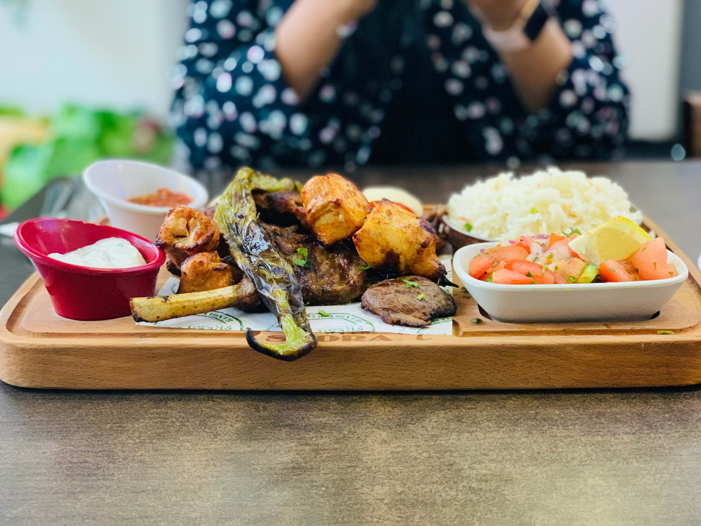 A spread of Greek food on a wooden board