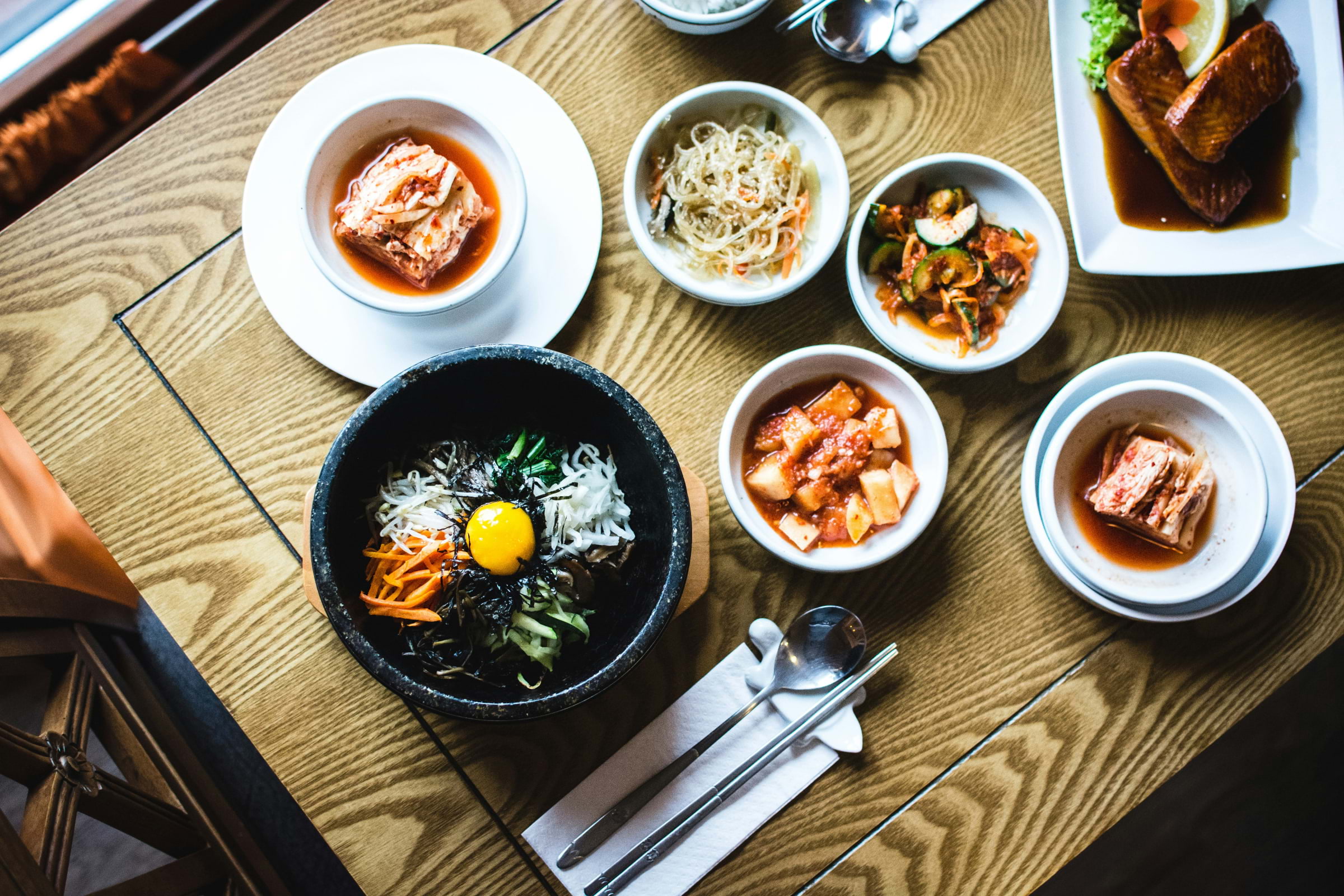 A spread of Korean food on a wooden table