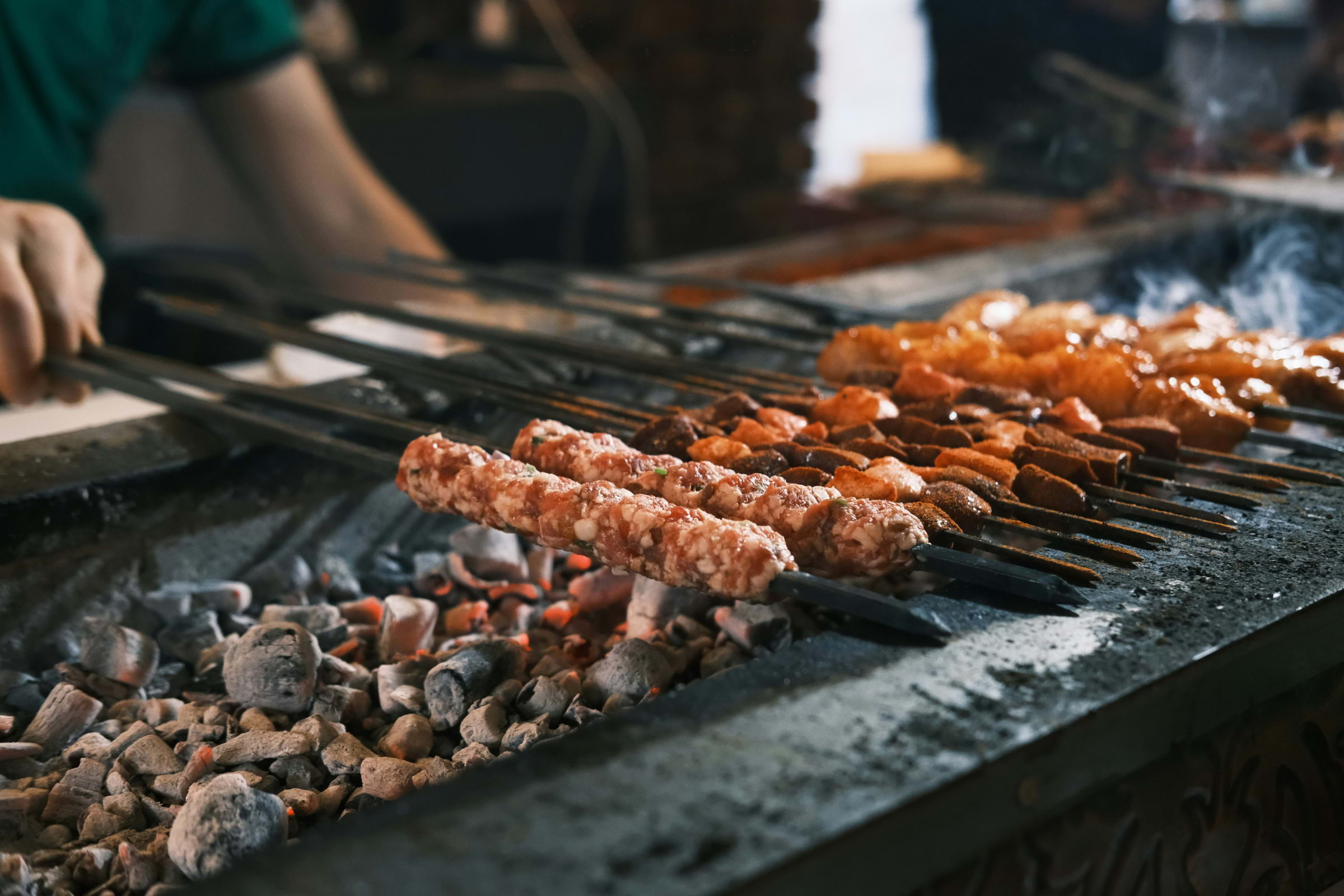 Turkish meat skewers being cooked on a charcoal grill