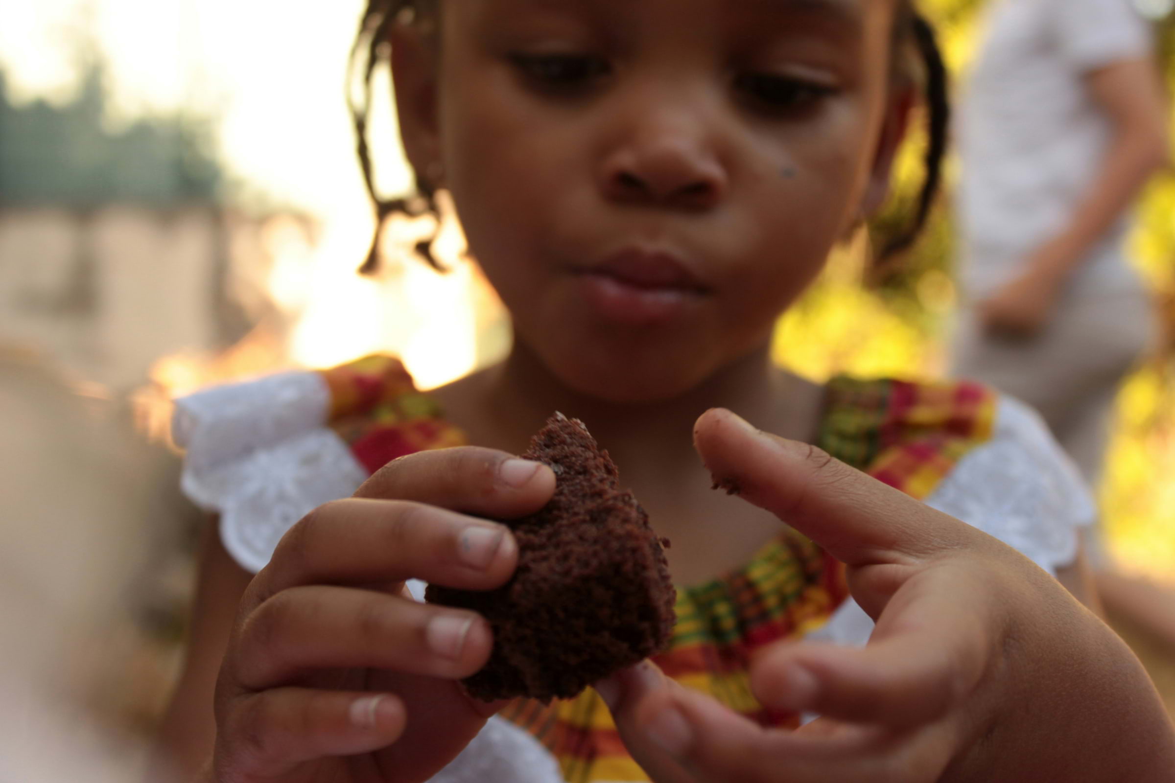 A child eating a piece of sponge cake