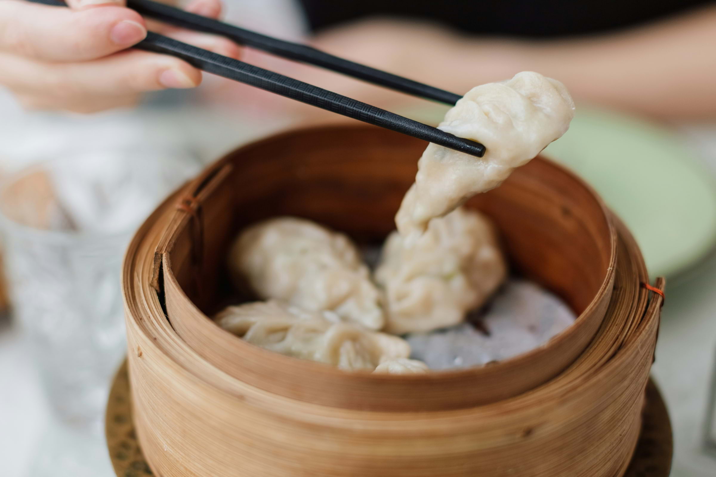 Someone picking up dim sum with chopsticks