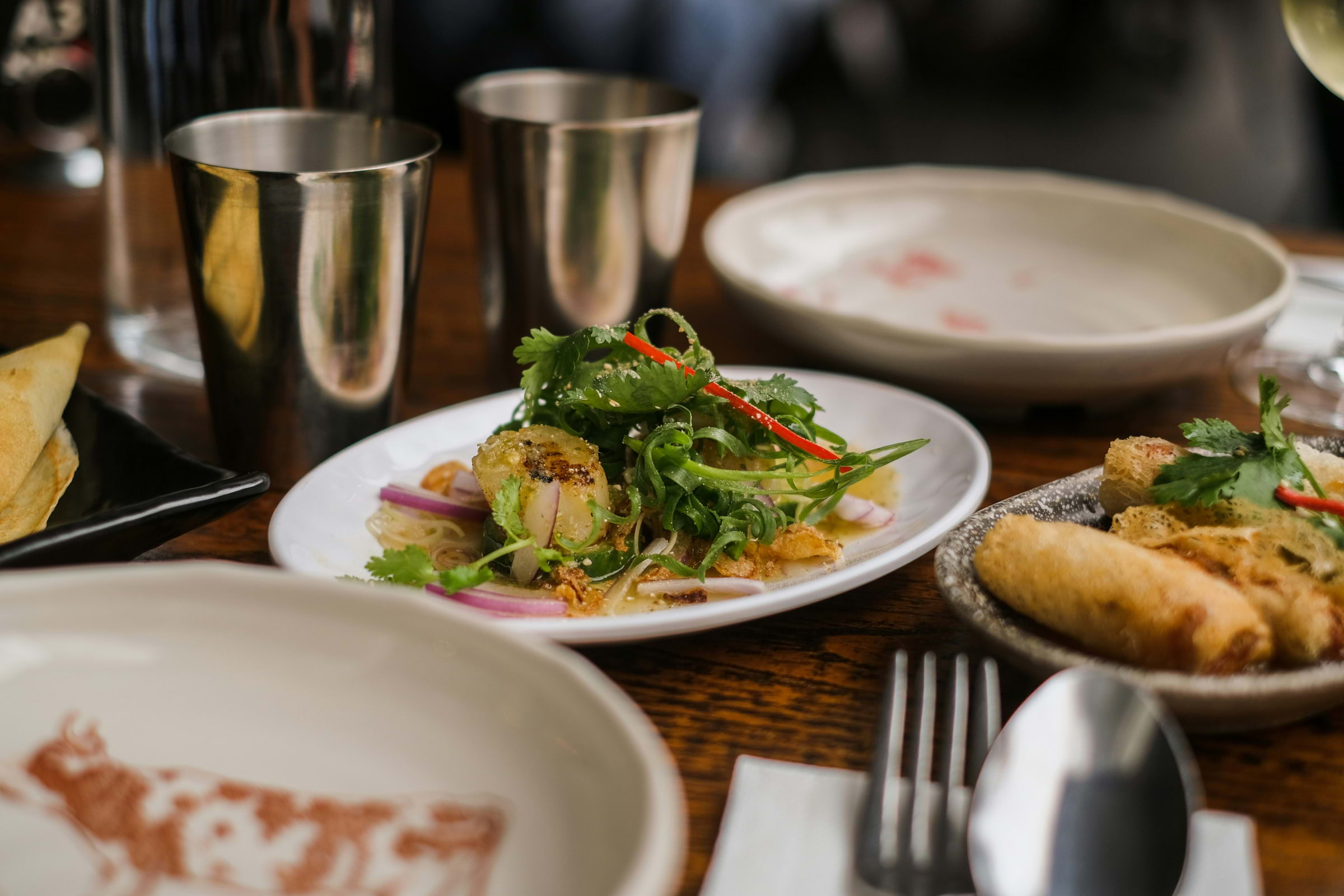 A spread of vegan Thai food on a wooden table