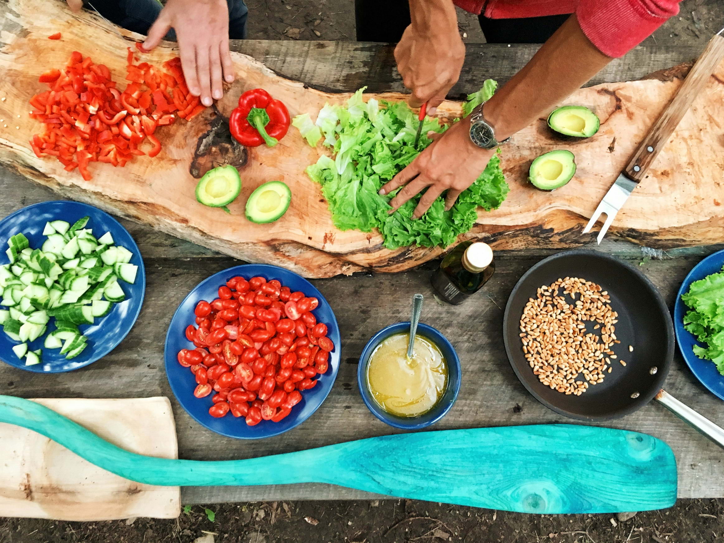 A bird's eye view of a table filled with colourful plates of food