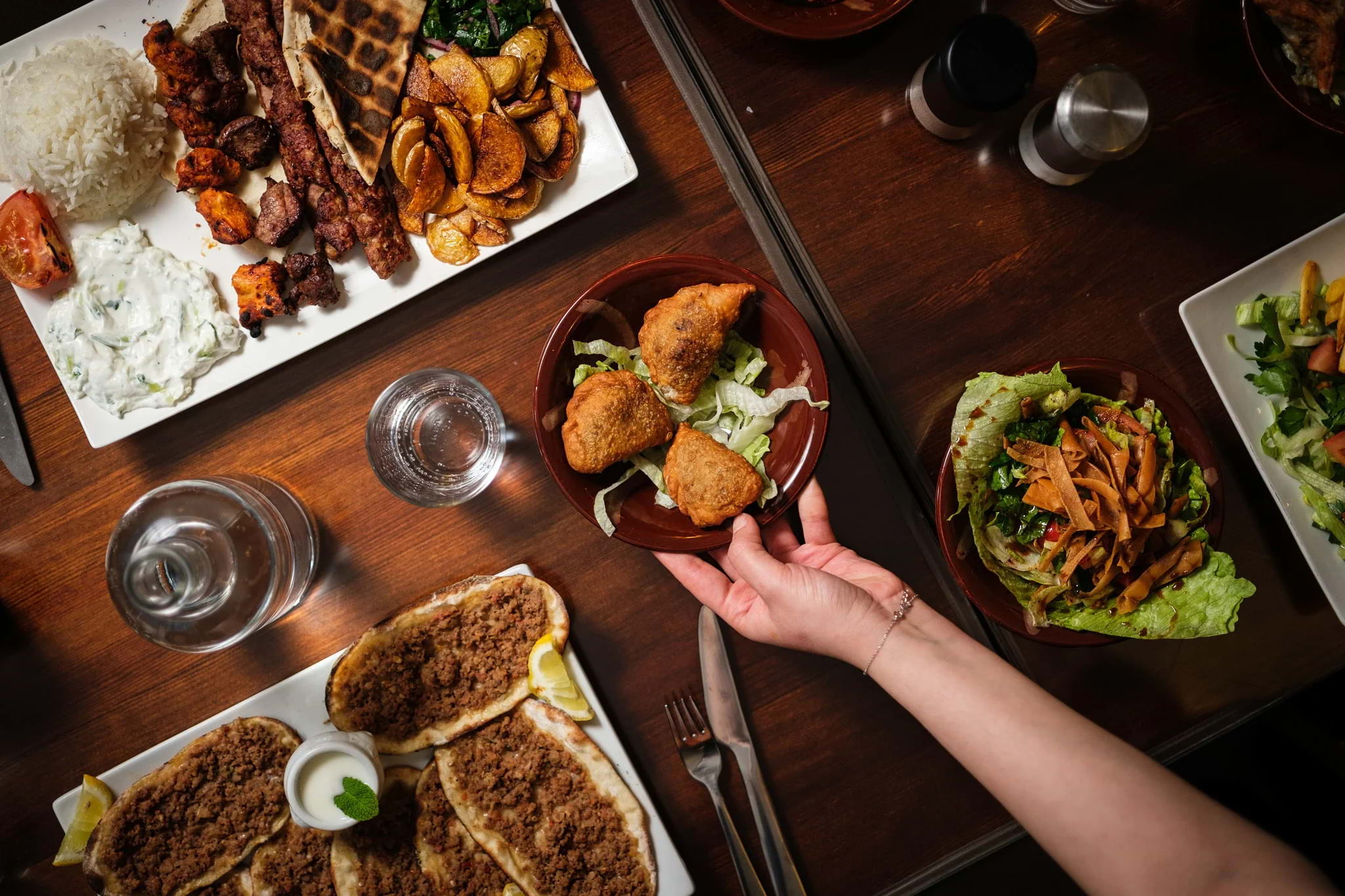 An assortment of halal dishes being laid out on a restaurant table