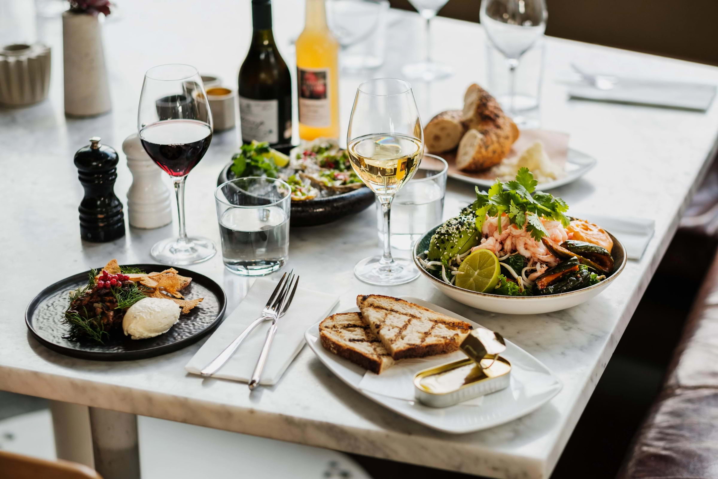 Lunch dishes and drinks laid out on a marble restaurant table