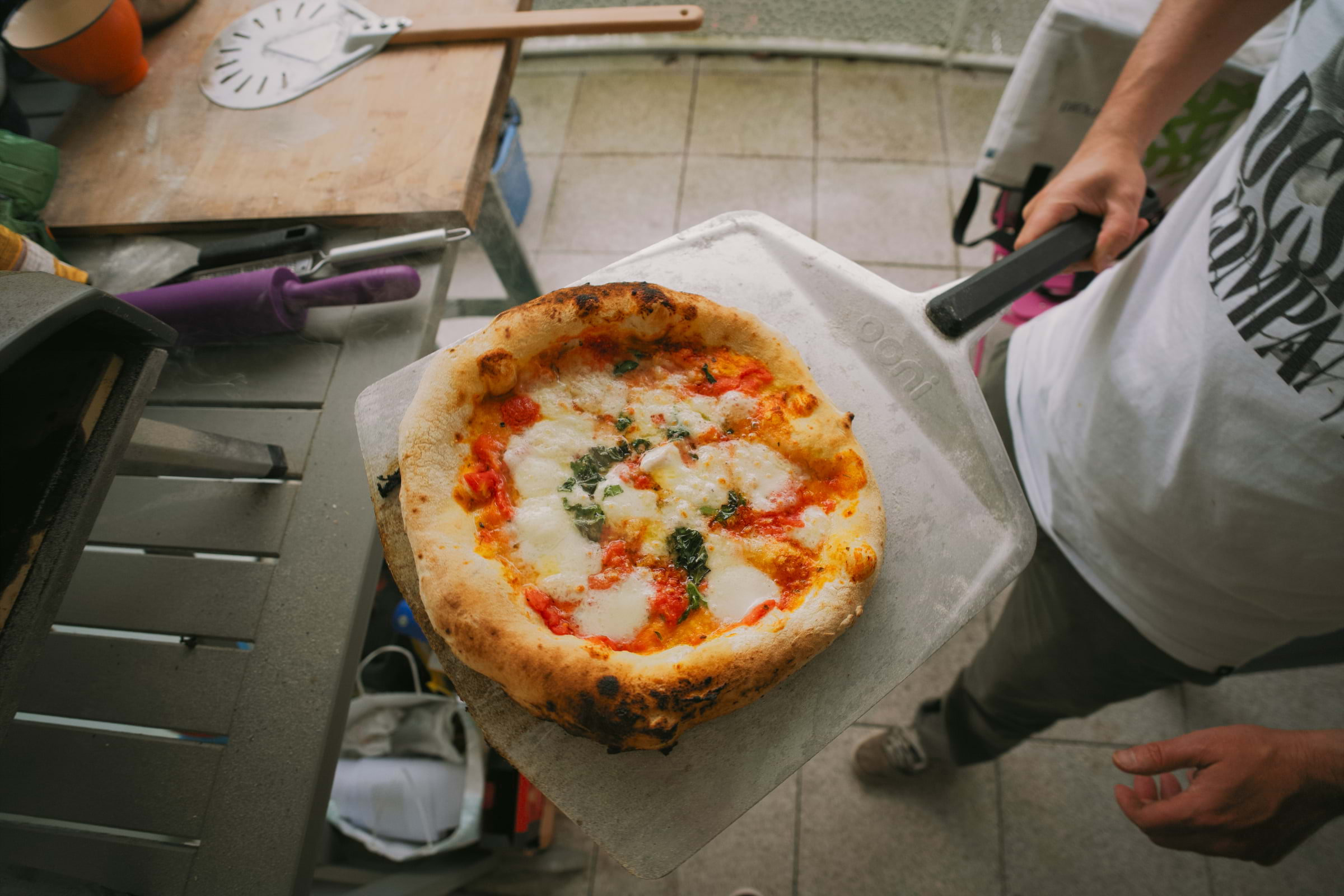 A pizza being taken out of the oven