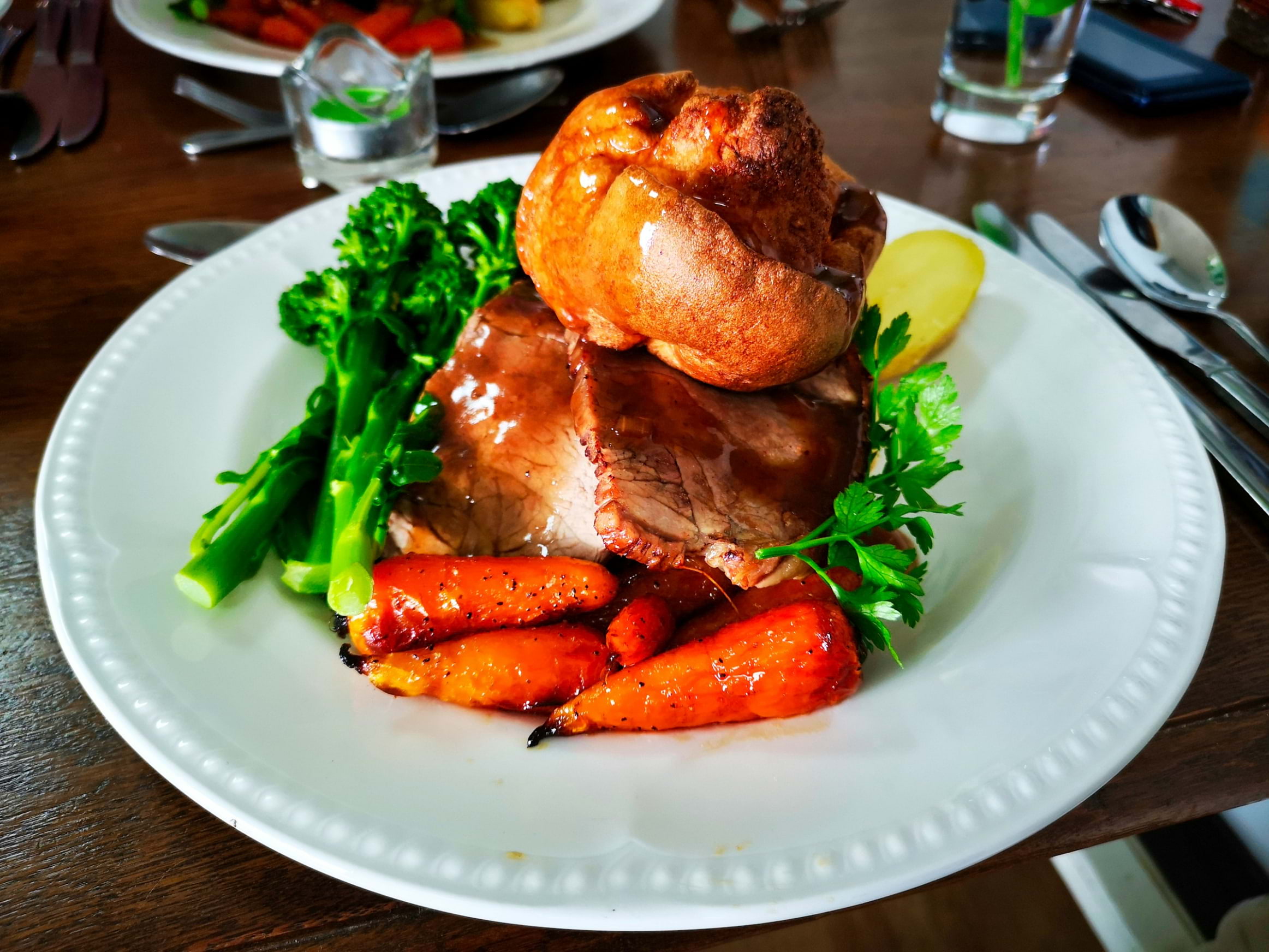A white plate topped with a Sunday roast with all the trimmings