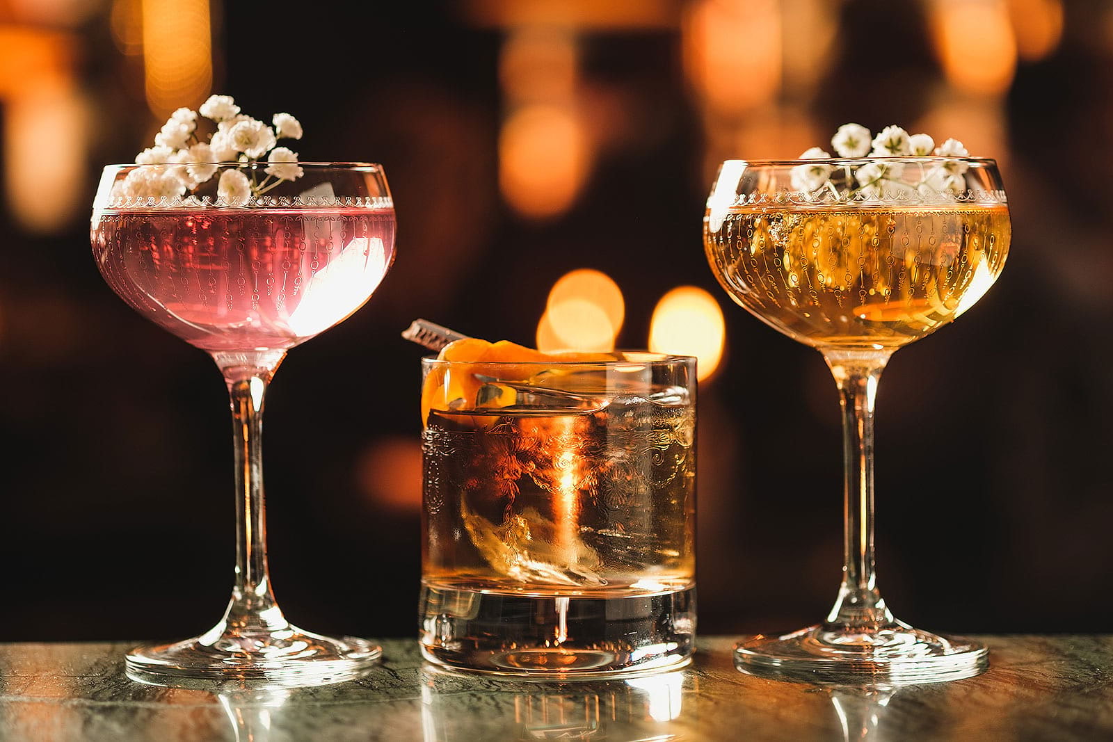 Three different cocktails on a marble bar counter
