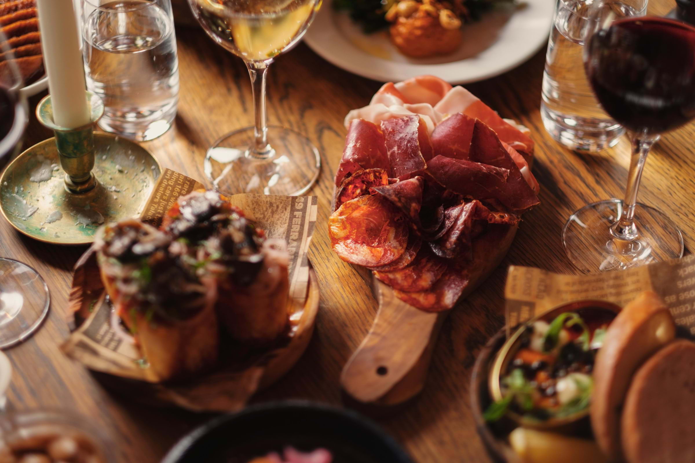 Charcuterie and Spanish tapas on a wooden restaurant table