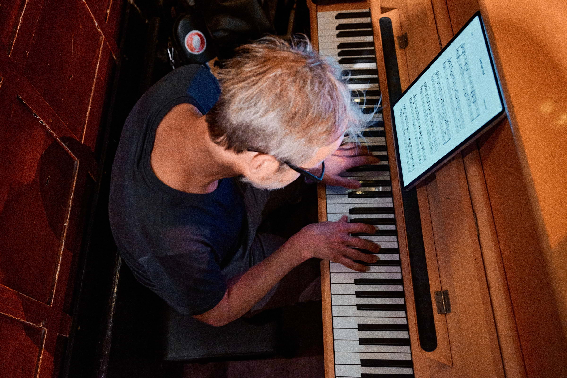 A bird's-eye photo of a pianist playing a piano in a bar