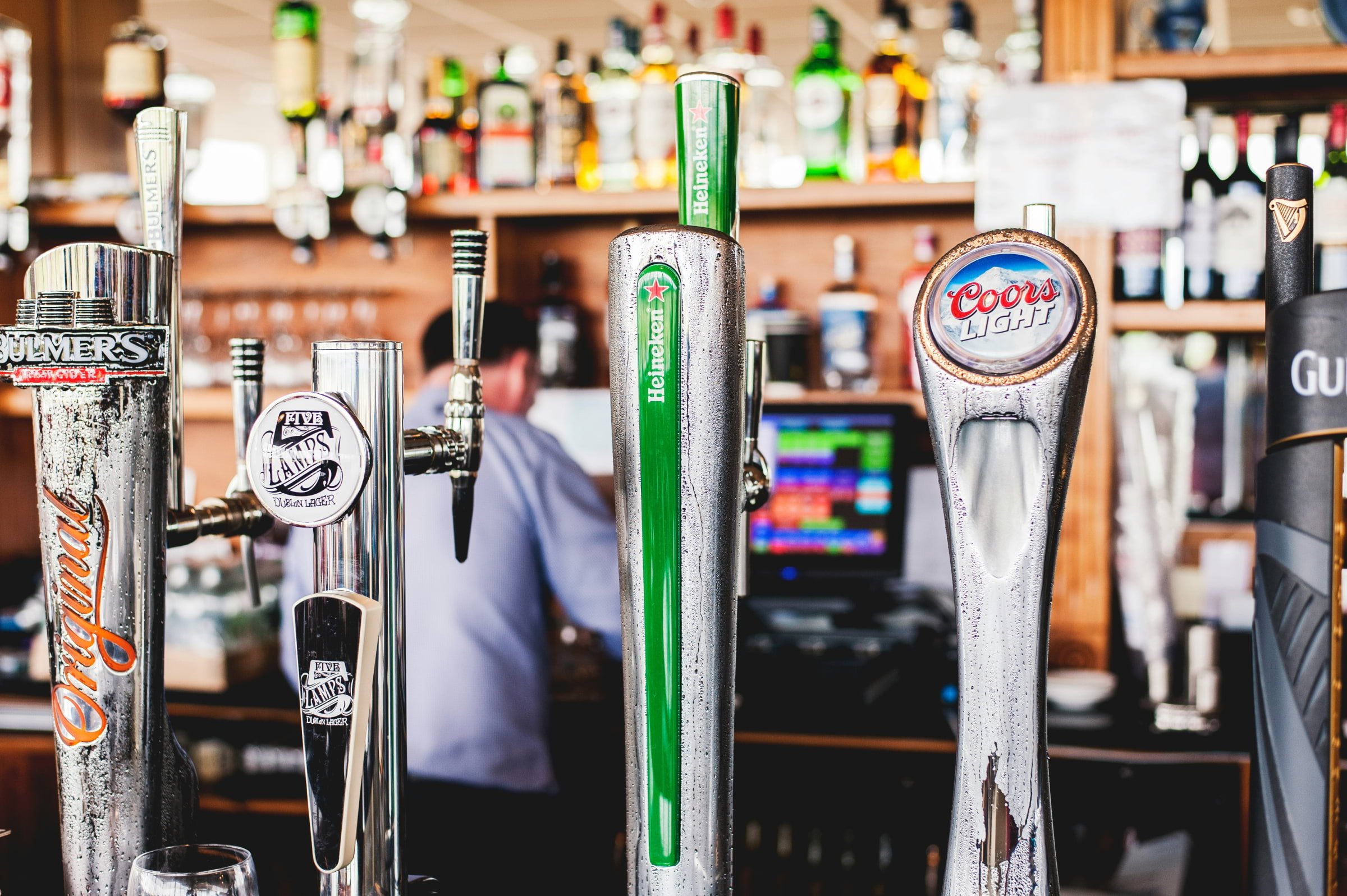 A few beer taps lined up at a pub.