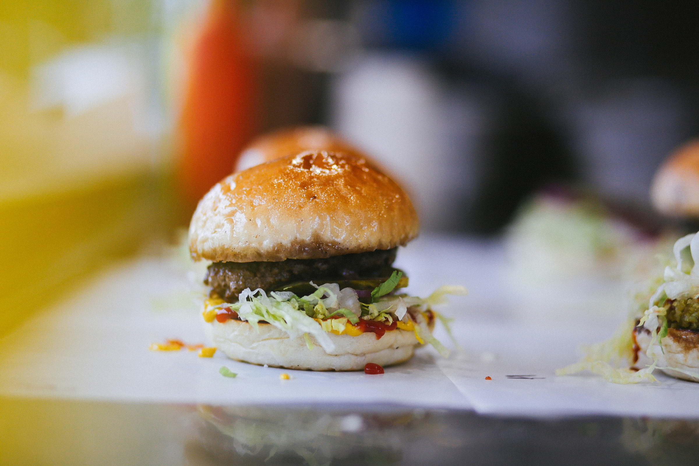 A cheeseburger with lettuce and tomato sauce on a table