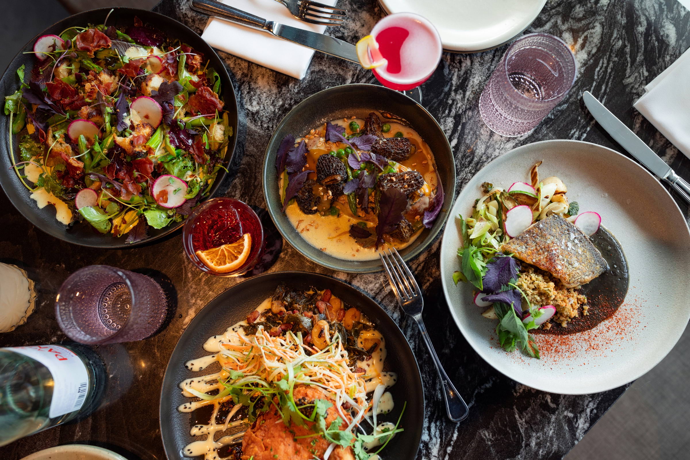 A spread of food on a dark table from above