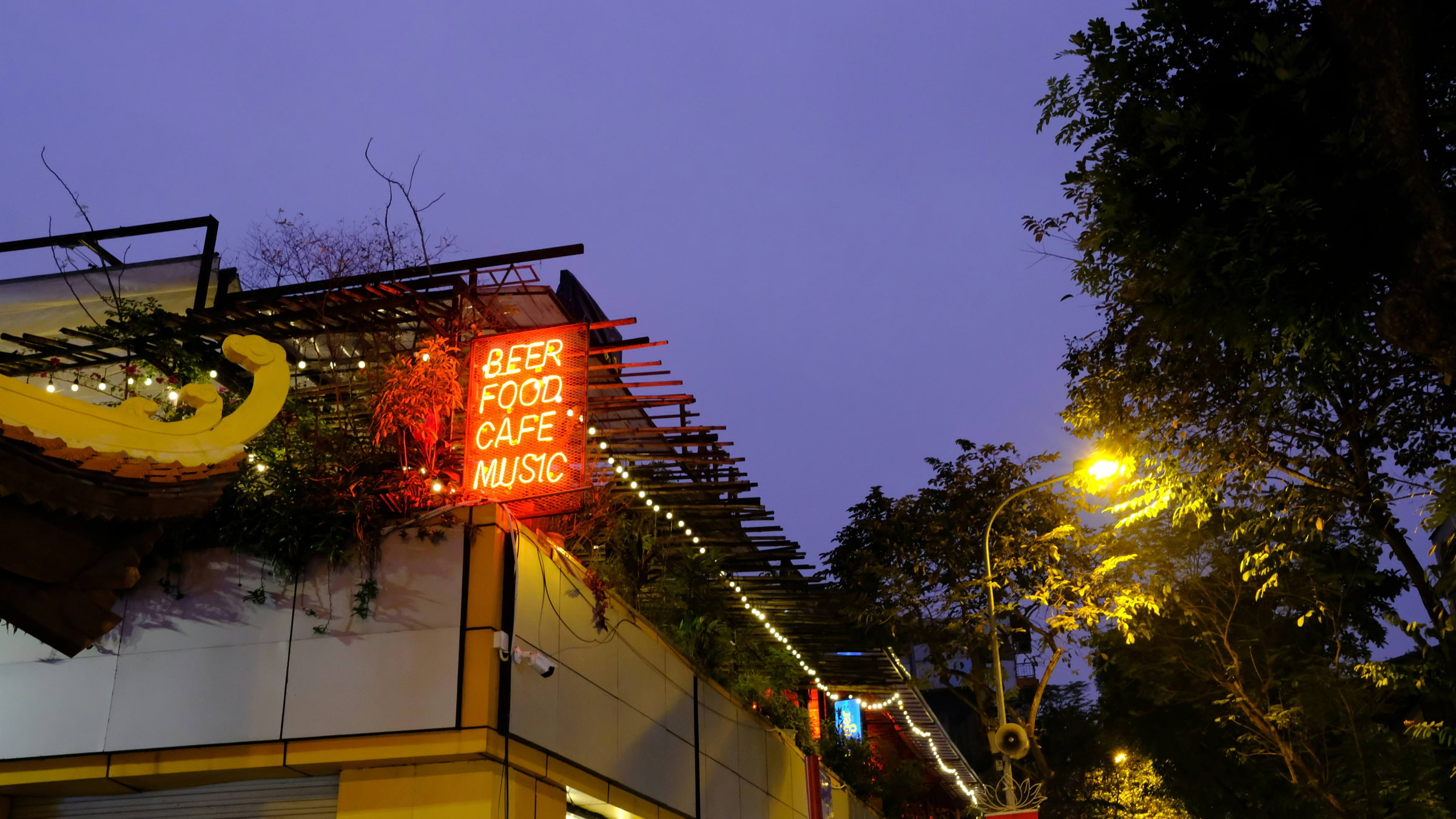 The outside of a bar with a sign saying 'beer, food, cafe, music'