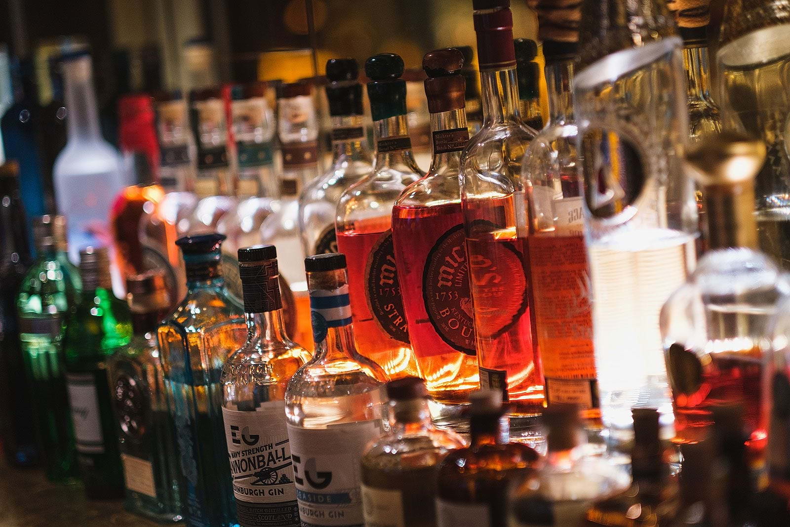 Bottles of spirits lined up on a bar shelf