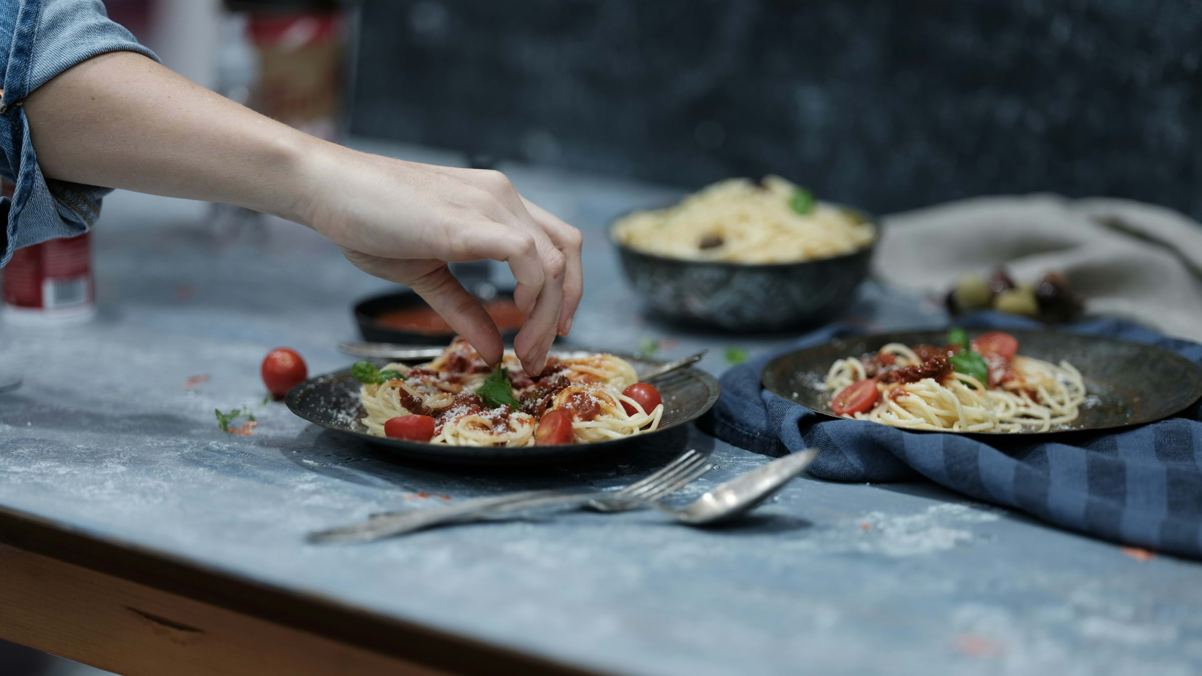 Someone plating up a bowl of spaghetti