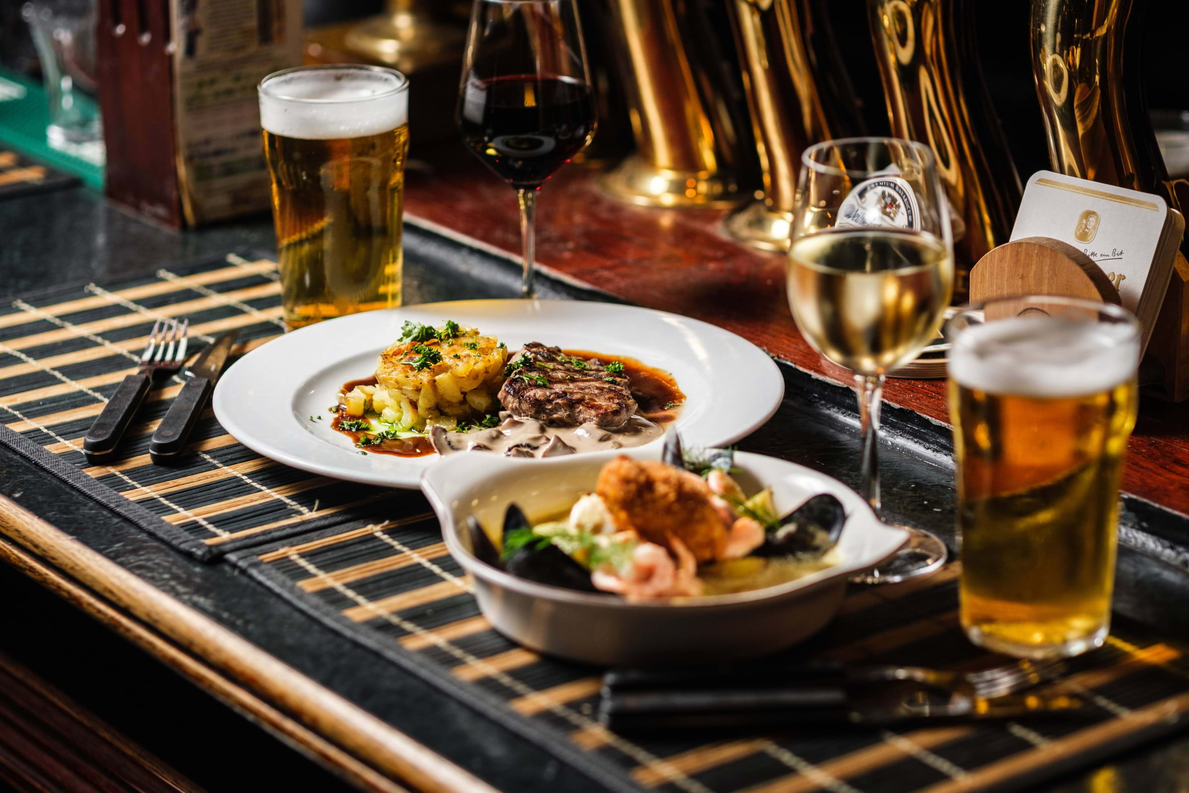 Food and drinks laid out on a bar counter in a pub