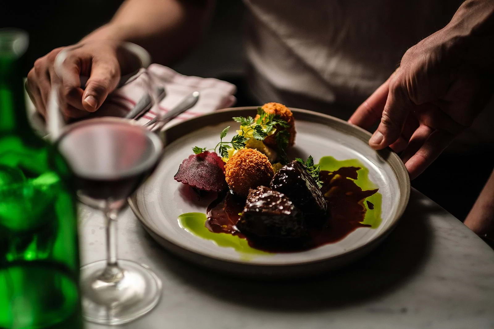 A dish being placed in front of a diner in a restaurant