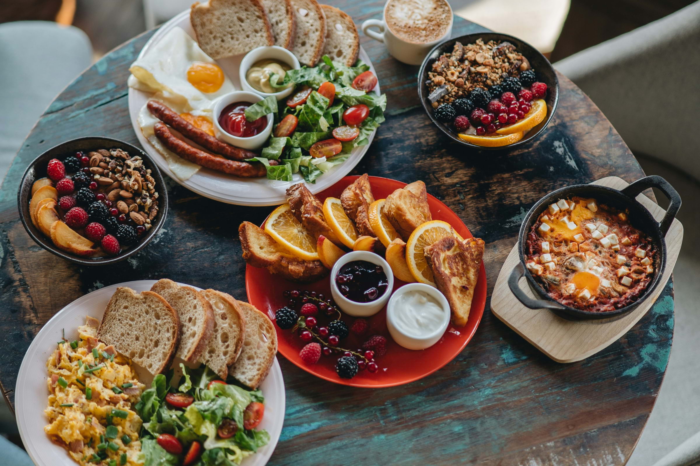 A spread of breakfast dishes on a dark wooden table
