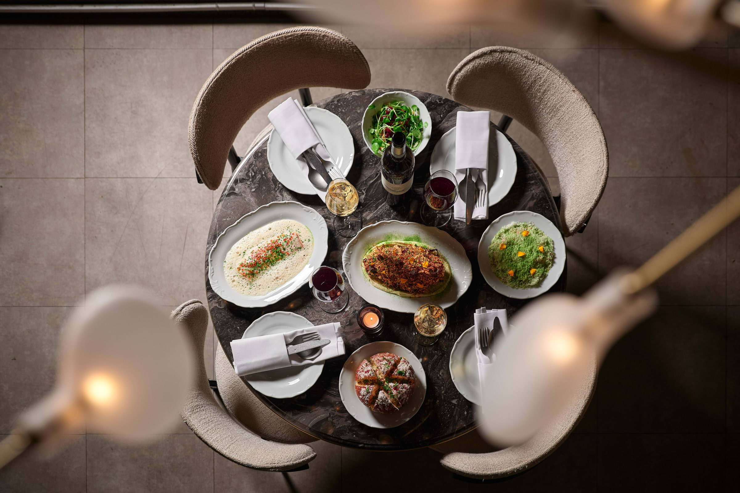 A bird's-eye view of a round restaurant table covered in dishes