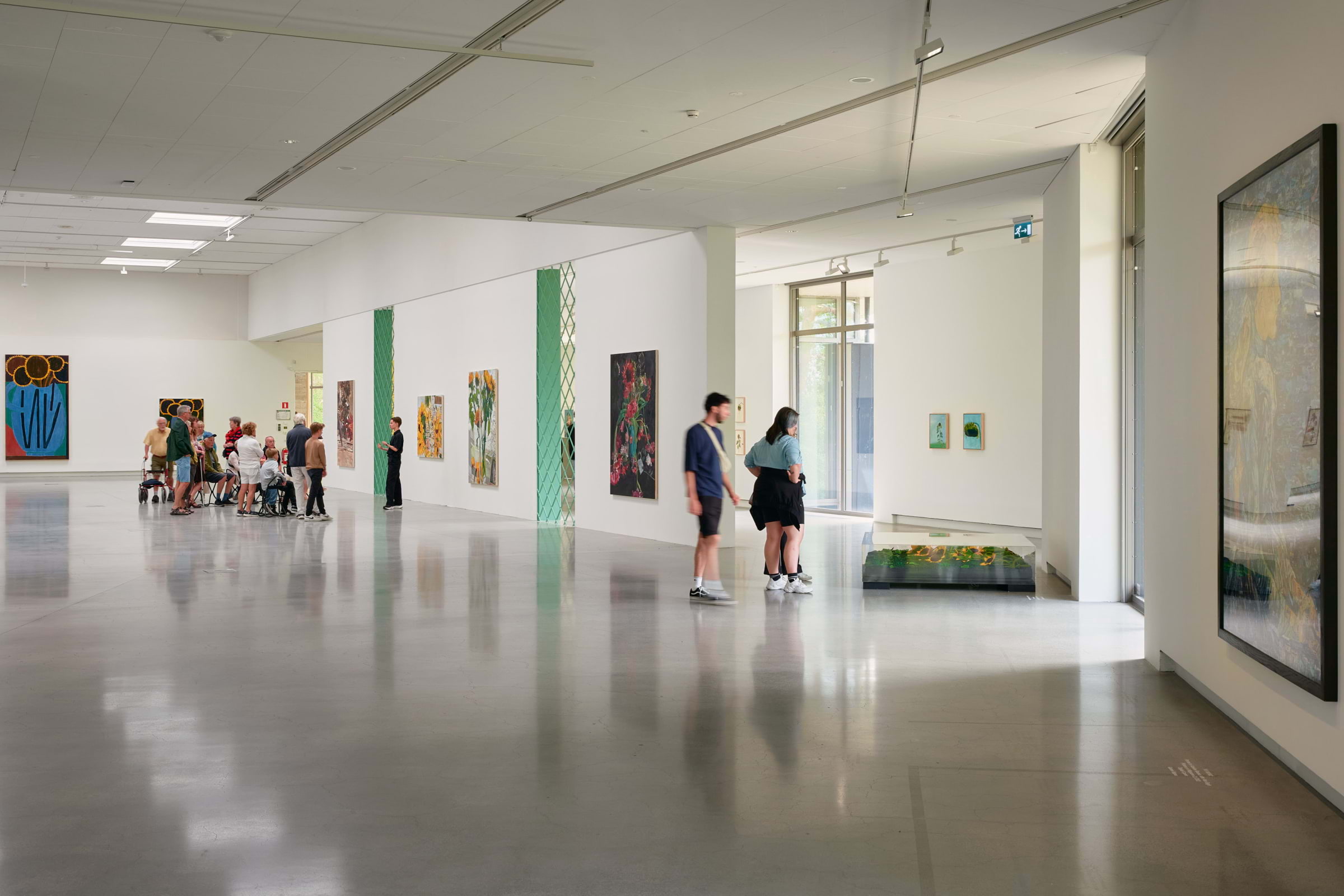 People looking at an exhibition in a gallery with white walls