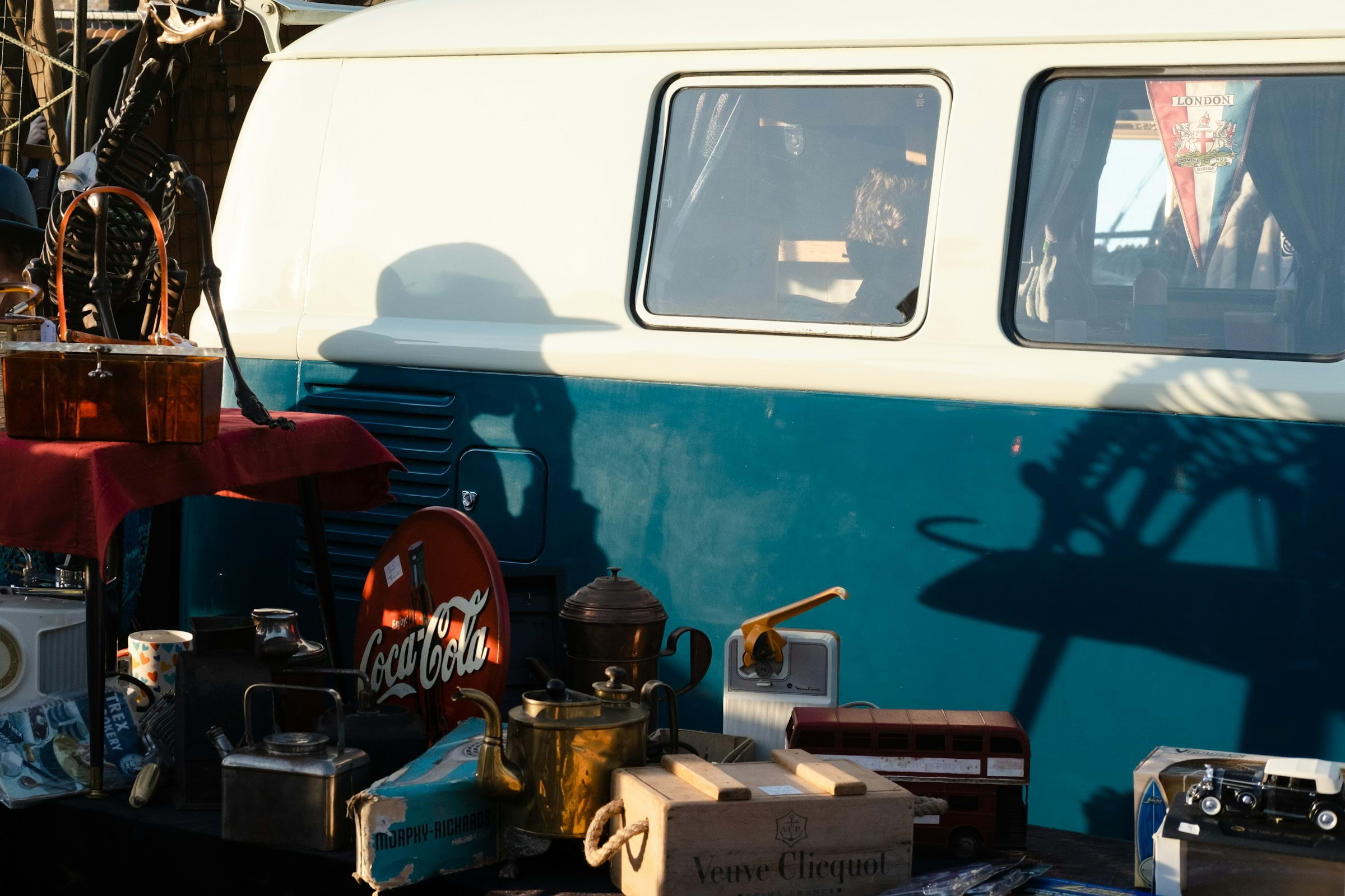 A blue and white van parked at a car boot sale