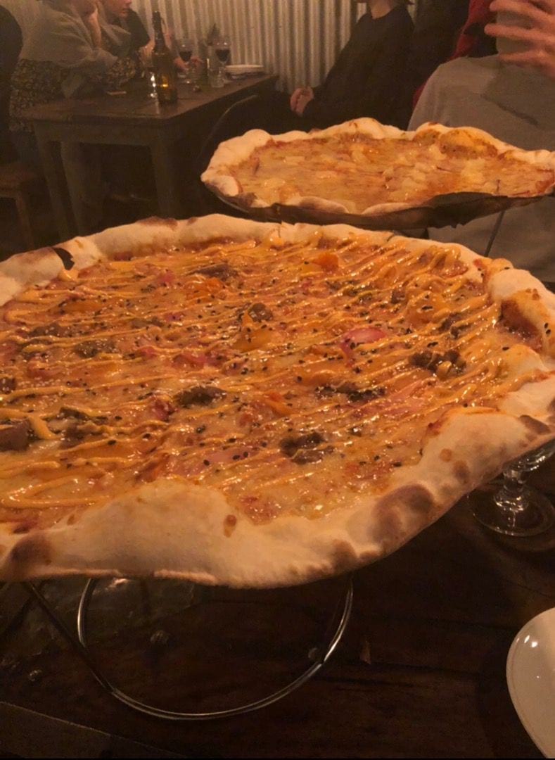 Pizza nr 7 och pizza med skinka+ananas i bakgrunden  – Bild från Crispy Pizza Bistro Vasastan av Mythu L. (2019-03-31)