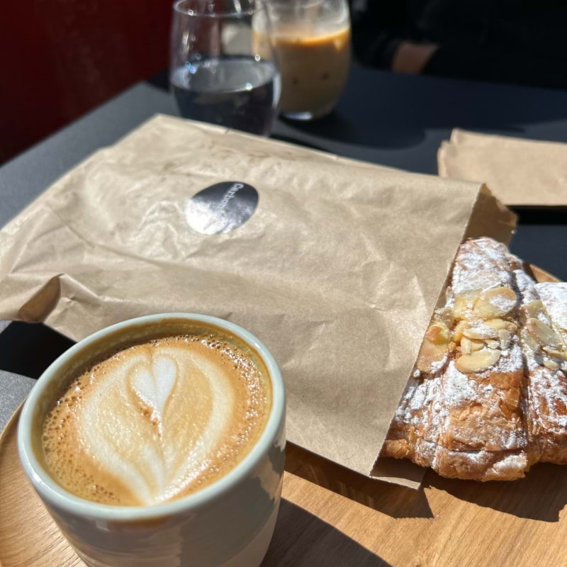 Flat white with almond croissant  – Photo from Carbon Kopi Fulham by Madiha S. (16/08/2023)