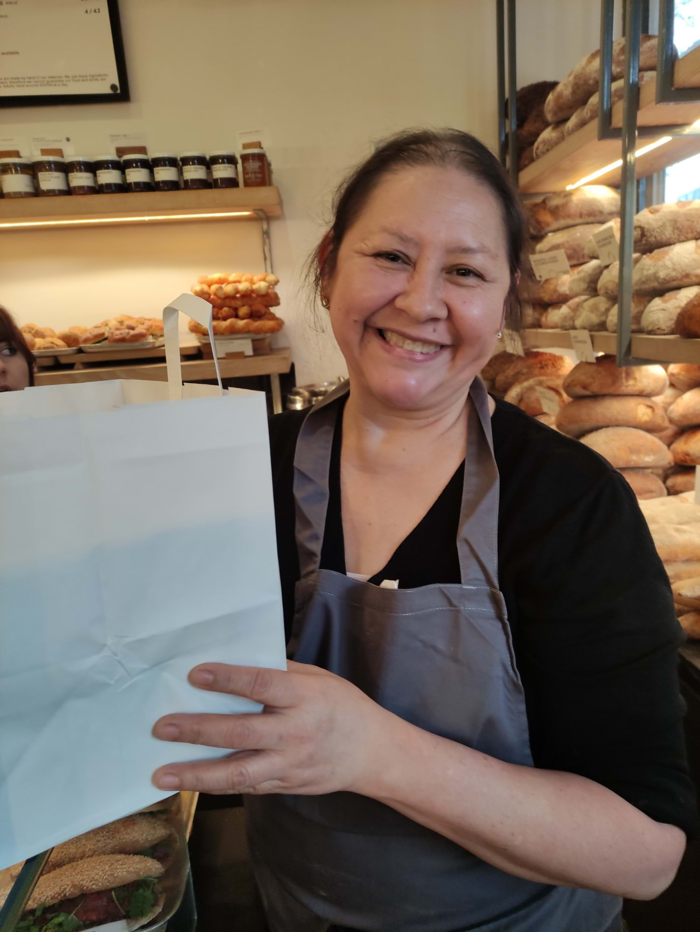 Elise handing over the pre packaged up pastries. – Bild från GAIL's Bakery Victoria Park av Alison N. (2023-12-21)