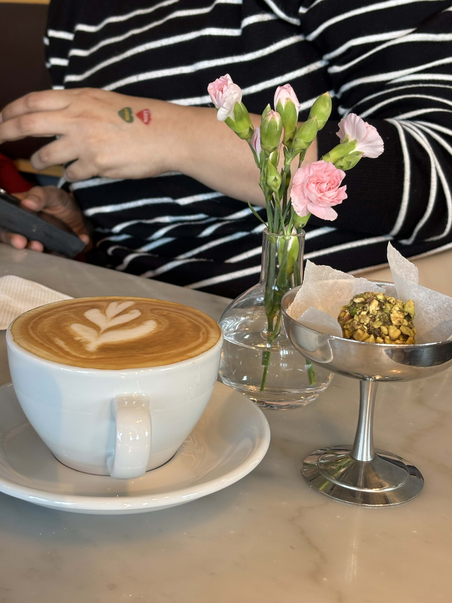 Cappuccino med pistasch boll – Bild från Café Vólta Regeringsgatan av Madiha S. (2026-05-06)